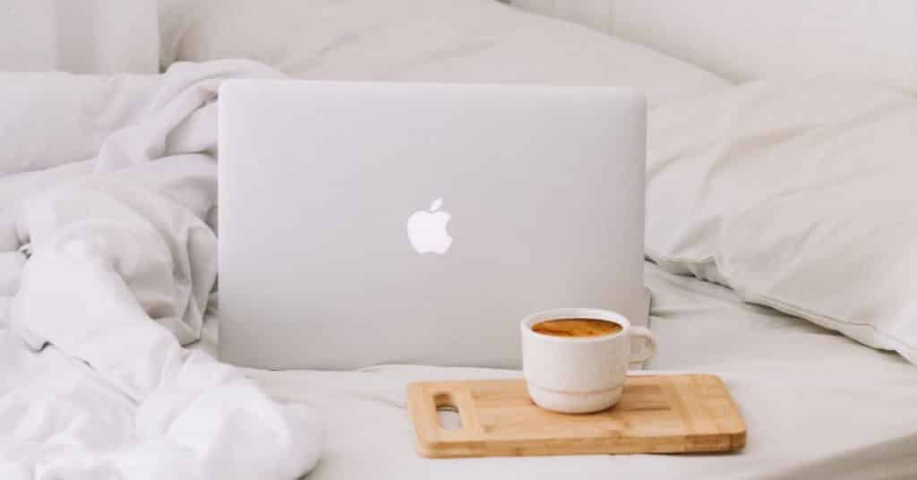 Ethical Brand Directory Blog | Top 10 Tips for Going Green | Cup of coffee and laptop on a bed