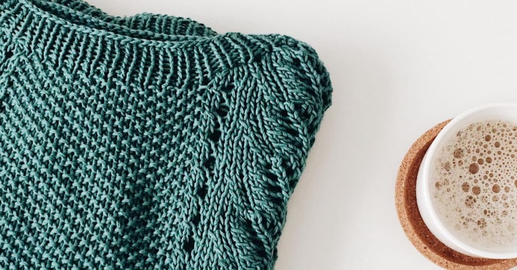 Ethical Brand Directory Blog | Conscious Shopping: How Small Changes Can Make a Big Difference | Editorial photo of knitted jumper and mug of coffee