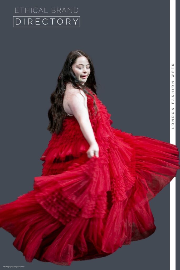 Ellie Goldstein wearing a red couture dress by Sanyukta Shrestha for London Fashion Week, walking for Ethical Brand Directory 