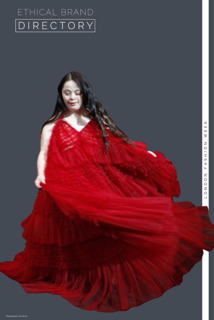 Ellie Goldstein wearing a red couture dress by Sanyukta Shrestha for London Fashion Week, walking for Ethical Brand Directory 